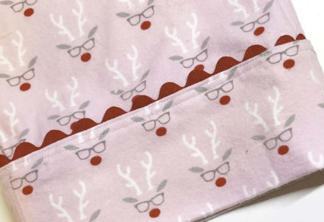 pink flannel pajamas with red ric rac trim and a reindeer design